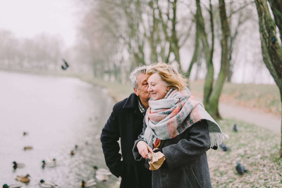 Ældre par holder om hinanden ved en sø i en park - senior dating for 60+ og 70+